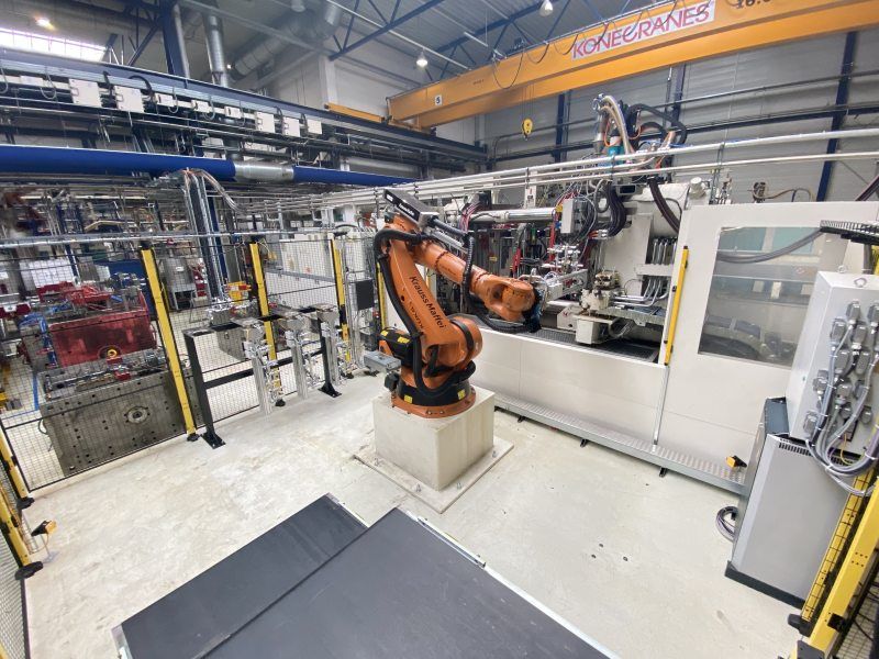Sicher im Schutzraum dank Radarlösung: Roboter am Entnahmebereich der Spritzgießmaschine, im Vordergrund das Transportband (Bild: Weidplas).