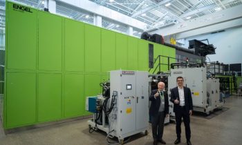 Marco Volpato (li.), Präsident und Vorstandsvorsitzender der Cannon Group, und Stefan Engleder, CEO der Engel Group, vor der großen Spritzgießzelle mit PUR-Anlage in einem Technikum (Bild: Engel).