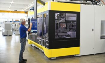 Auf dieser Extrusionsblasformmaschine wird eine Live-Demonstration mit glasklaren PET-Griffflaschen gezeigt (Bild: Bekum).